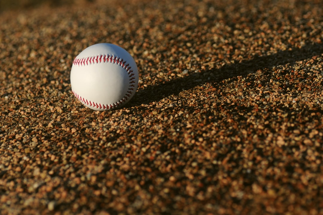 white and red baseball on brown soil at daytime - Sun Dial, tags: nft - unsplash